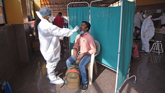 A health worker collects a swab sample from a man to test for coronavirus infection, at NMMC Hospital in Navi Mumbai on January 20. In November, average Covid-19 cases were at 4,775, which fell to 3,892 in December and in January, as of January 21, it further dropped to 3,174.(Bachchan Kumar / HT Photo)