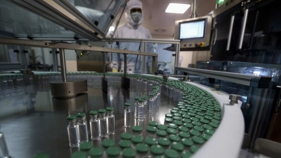 An employee operates a Covid-19 vaccine filling machine at the Serum Institute of India in Pune on January 21. There was no vaccination drive on January 21 as planned by the Maharashtra government. It has decided to conduct vaccination sessions only four days a week — Tuesday, Wednesday, Friday and Saturday, HT reported.(Rafiq Maqbool / AP)