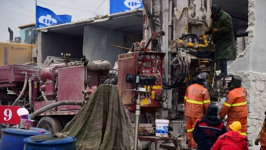 Members of a rescue team working at the site of a gold mine explosion where 22 miners are trapped underground in Qixia, in eastern China's Shandong province.(AFP) Members of a rescue team working at the site of a gold mine explosion where 22 miners are trapped underground in Qixia, in eastern China's Shandong province.(AFP)