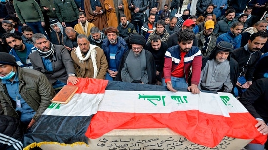Iraqi mourners pray over the coffin of a victim who was killed in a twin suicide bombing in central Baghdad, during a funeral in the holy city of Najaf on January 21, 2021. (AFP) Iraqi mourners pray over the coffin of a victim who was killed in a twin suicide bombing in central Baghdad, during a funeral in the holy city of Najaf on January 21, 2021. (AFP)
