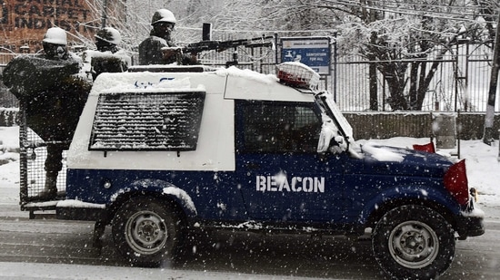 Security personnel keep vigil during fresh snowfall in Srinagar on Saturday. (ANI Photo)