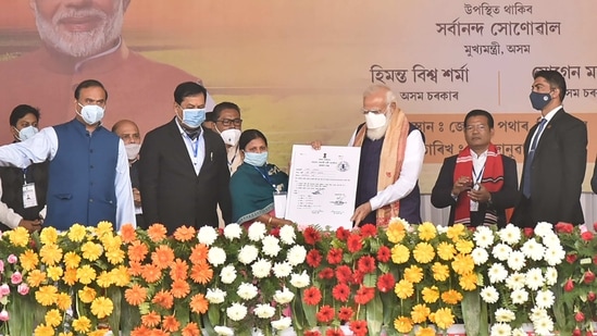 Prime Minister Narendra Modi distributes 'Land Patta' to a woman during a public meeting, at Jerenga Pathar in Sivasagar District of Assam. (PTI Photo) Prime Minister Narendra Modi distributes 'Land Patta' to a woman during a public meeting, at Jerenga Pathar in Sivasagar District of Assam. (PTI Photo)