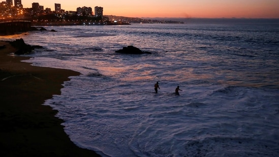 People are seen on a beach as the national emergency office, ONEMI, through a message on Chileans' cell phones, urges people to abandon coastal areas after a quake at the Chilean Antarctic territory. (REUTERS)