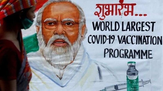 A woman walks past a painting of Indian Prime Minister Narendra Modi a day before the inauguration of the Covid-19 vaccination drive on a street in Mumbai, India, January 15, 2021. (REUTERS)