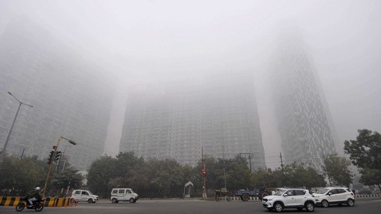 A view of a skyscraper engulfed in dense fog in Noida on January 22. Delhi recorded a maximum temperature of 20.4 degrees Celsius, 1 degree below normal and minimum temperature of 8 degrees Celsius on January 23.(Sunil Ghosh / HT Photo)