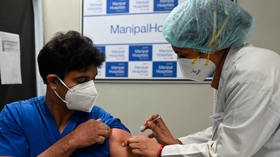 A medical worker (R) inoculates a medical staff with a Covid-19 coronavirus vaccine at the Manipal Hospital, in New Delhi on January 19, 2021. (Photo by Money SHARMA / AFP)(AFP)