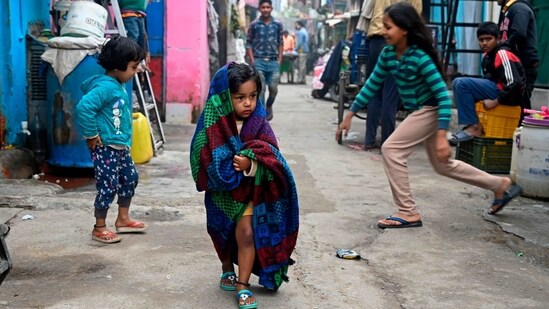 A child wearing a blanket walks through an alley of a residential area on a cold winter day in New Delhi on January 24, 2021. (Photo by Sajjad HUSSAIN / AFP)(AFP)