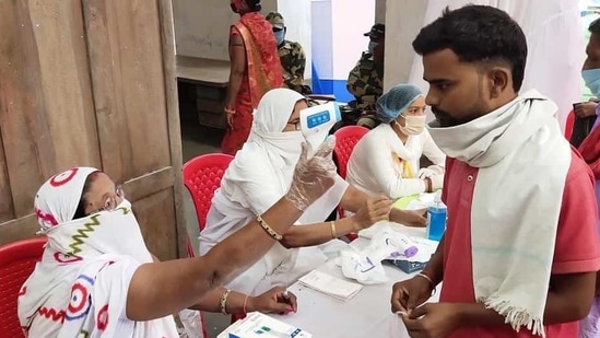 Bihar Election Results 2020: Voters undergoing thermal screening at a polling booth as they stand in queues to cast their votes for the second phase of the Bihar Assembly Election, in Begusarai.(ANI) Bihar Election Results 2020: Voters undergoing thermal screening at a polling booth as they stand in queues to cast their votes for the second phase of the Bihar Assembly Election, in Begusarai.(ANI)