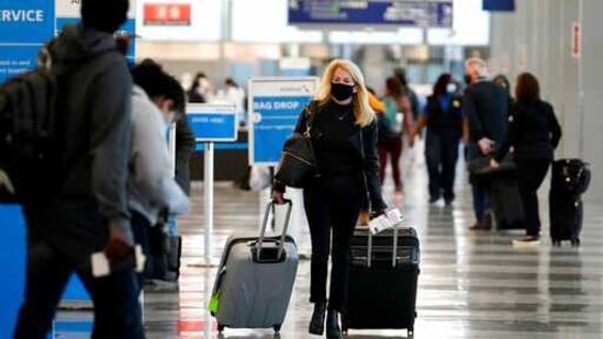 A traveler wears a mask as she walks through Terminal 3 at O'Hare International Airport in Chicago.(AP File Photo )