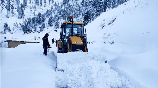 An earth-mover clears snow from a road following heavy snowfall, at Bhaderwah, in Doda district of J&K, on January 24. (PTI)