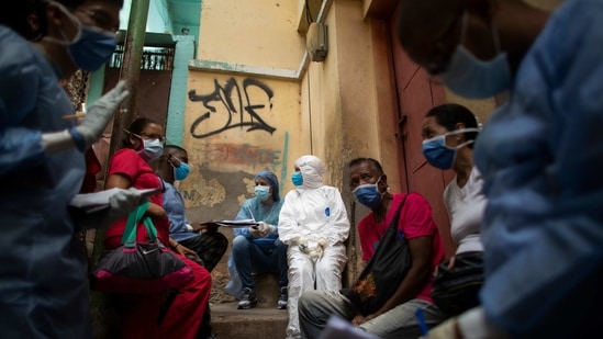 Health workers prepare to enter a neighbourhood during door-to-door Covid-19 testing to control a surge of the virus using PCR and rapid tests on January 23 in Caracas, Venezuela. The virus continues to chart an unyielding path across communities, testing governments and health care systems globally.( Leonardo Fernandez Viloria / Getty Images)
