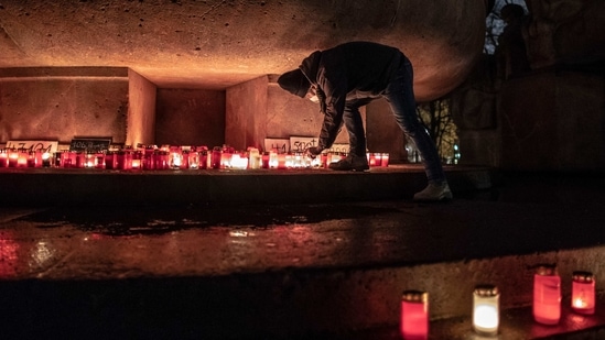 A person places candles at a makeshift memorial for Covid-19 victims at Arnswalder Platz on January 24 in Berlin, Germany. Since it emerged in late 2019, Covid-19 has killed more than 2.1 million people, according to an AFP tally from official figures.(Omer Messinger / Getty Images)