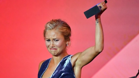 Australian of the Year winner Grace Tame raises her award during a ceremony in Canberra, Monday, Jan. 25, 2021. Tame, 26, pushed for legal changes so she could speak out about being a survivor of the sexual abuse she went through as a 15-year-old at the hands of a math teacher. (Mick Tsikas/AAP Image via AP)(AP)