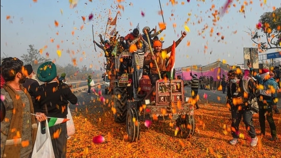 Farmers shower flower petals on fellow farmers riding on their tractors after breaking the police barricades at Singhu border during the 'Kisan Gantantra Parade' on Republic Day in New Delhi. (PT) Farmers shower flower petals on fellow farmers riding on their tractors after breaking the police barricades at Singhu border during the 'Kisan Gantantra Parade' on Republic Day in New Delhi. (PT)
