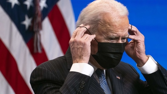 US President Joe Biden places a protective mask on during an executive signing event at the Eisenhower Executive Office Building in Washington. (Bloomberg Photo ) US President Joe Biden places a protective mask on during an executive signing event at the Eisenhower Executive Office Building in Washington. (Bloomberg Photo )