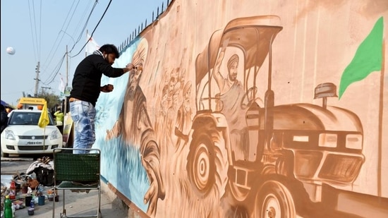 An artist paints a wall in support of protesting farmers, at Singhu border in New Delhi on January 25. (ANI) An artist paints a wall in support of protesting farmers, at Singhu border in New Delhi on January 25. (ANI)