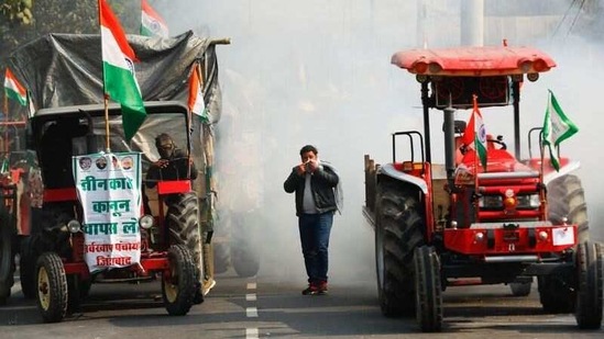 A farmer takes cover from tear gas shells fired by Delhi Police during the tractor rally in New Delhi on January 26.(Adnan Abidi / REUTERS)