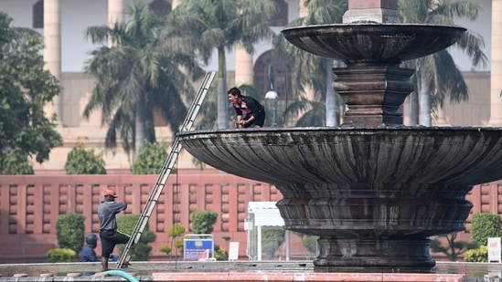 Men work near the Parliament in New Delhi. (AFP) Men work near the Parliament in New Delhi. (AFP)