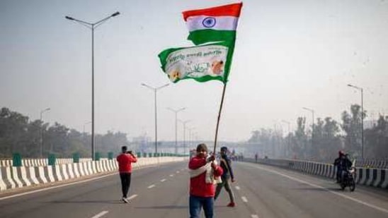 A protesting farmer waves an Indian flag and a farmer union flag as he marches with others to the capital breaking police barricades during Republic Day celebrations in New Delhi.(AP) A protesting farmer waves an Indian flag and a farmer union flag as he marches with others to the capital breaking police barricades during Republic Day celebrations in New Delhi.(AP)