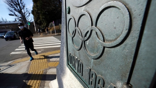 A man wearing a face mask to help protect himself from the coronavirus runs near plaques in honor of 1964 Tokyo Olympics Monday, Jan. 25, 2021 in Tokyo. The Japanese capital confirmed more than 600 new coronavirus cases on Monday. (AP Photo/Eugene Hoshiko)(AP) A man wearing a face mask to help protect himself from the coronavirus runs near plaques in honor of 1964 Tokyo Olympics Monday, Jan. 25, 2021 in Tokyo. The Japanese capital confirmed more than 600 new coronavirus cases on Monday. (AP Photo/Eugene Hoshiko)(AP)