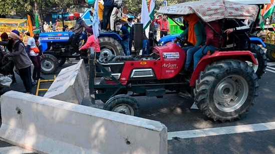 Farmers on tractors remove concrete barricades installed to prevent them from entering the city during the tractor rally in New Delhi on January 26.(Sajjad Hussain / AFP) Farmers on tractors remove concrete barricades installed to prevent them from entering the city during the tractor rally in New Delhi on January 26.(Sajjad Hussain / AFP)