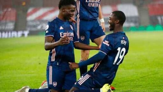 Arsenal's Bukayo Saka, left, celebrates with Arsenal's Nicolas Pepe after scoring his side's second goal during an English Premier League soccer match between Southampton and Arsenal at the St Mary's stadium in Southampton, England, Tuesday Jan. 26, 2021.(AP)