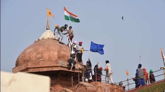 Farmers put up flags on a dome of Red Fort after their tractor parade on Republic Day, in New Delhi. (PTI) Farmers put up flags on a dome of Red Fort after their tractor parade on Republic Day, in New Delhi. (PTI)