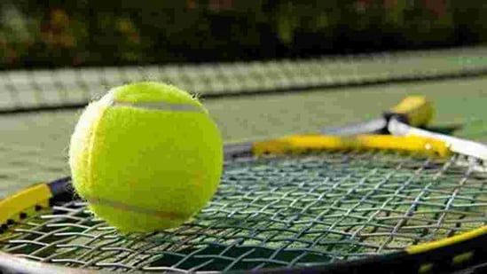 A tennis racket and new tennis ball on a freshly painted tennis court A tennis racket and new tennis ball on a freshly painted tennis court
