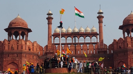 FILE - In this Tuesday, Jan. 26, 2021, file photo, a Sikh man hangs on to pole holding a Sikh religious flag along with a farm union flag at the historic Red Fort monument during a farmers protest against new farm laws in New Delhi, India. A sea of tens of thousands of farmers riding tractors and horses stormed India’s historic Red Fort this week — a dramatic escalation of their protests, which are posing a major challenge to Prime Minister Narendra Modi’s government. (AP Photo/Dinesh Joshi, File)(AP) FILE - In this Tuesday, Jan. 26, 2021, file photo, a Sikh man hangs on to pole holding a Sikh religious flag along with a farm union flag at the historic Red Fort monument during a farmers protest against new farm laws in New Delhi, India. A sea of tens of thousands of farmers riding tractors and horses stormed India’s historic Red Fort this week — a dramatic escalation of their protests, which are posing a major challenge to Prime Minister Narendra Modi’s government. (AP Photo/Dinesh Joshi, File)(AP)