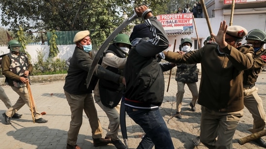 A man wields his sword against a policeman during a clash between protesting farmers and a group of people shouting anti-farmer slogans, at a site of the protest against farm laws at Singhu border near New Delhi, India January 29, 2021. REUTERS/Anushree Fadnavis(REUTERS)