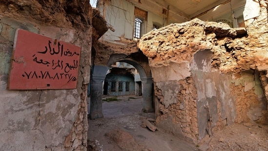 A sign on the wall of a house owned by a Kurdish family reads in Arabic "House for sale" with a phone number to call, in the Old City of Mosul on January 26, 2021. (Zaid AL-Obeidi / AFP)