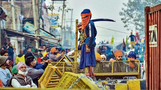 A protester stands on a barricade that was put up by the police on Thursday at Singhu border.(PTI Photo)