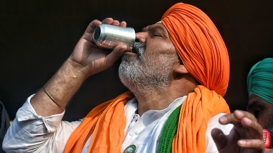 BKU leader Rakesh Tikait drinks water brought from nearby villages during a protest against the three farm laws at Delhi Ghazipur border in New Delhi on Saturday. (ANI Photo) BKU leader Rakesh Tikait drinks water brought from nearby villages during a protest against the three farm laws at Delhi Ghazipur border in New Delhi on Saturday. (ANI Photo)