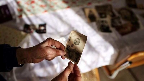 Holocaust survivor Leah Nebenzahl holds a photograph of herself as a baby during her interview with Reuters in Jerusalem. (REUTERS)