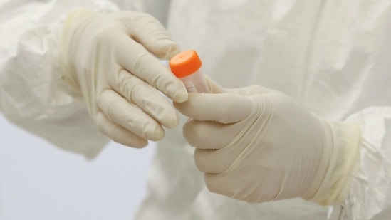 A health worker closes a tube with the coronavirus test sample. (REUTERS)