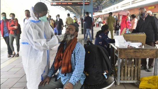 A healthcare staff collects swab sample of a passenger at Dadar station in Mumbai on Sunday. (Anshuman Poyrekar/HT Photo)