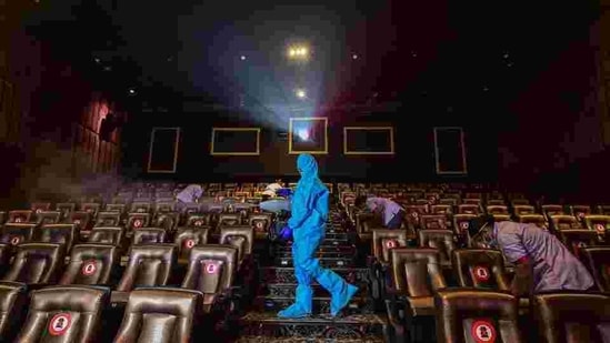 A worker wearing PPE kit sanitises a cinema hall. New SOPs have been announced. (PTI) A worker wearing PPE kit sanitises a cinema hall. New SOPs have been announced. (PTI)