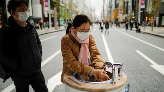 A shopper washes her hands using a mobile handwashing machine called 'WOSH', installed to prevent the spread of the Covid-19 in Tokyo. (REUTERS)