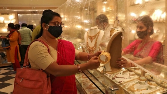 FILE PHOTO: Woman looks at a gold necklace at a jewellery showroom during Dhanteras, a Hindu festival associated with Lakshmi, the goddess of wealth, amidst the spread of COVID-19 in Kolkata, India, November 13, 2020. REUTERS/Rupak De Chowdhuri/File Photo(REUTERS)