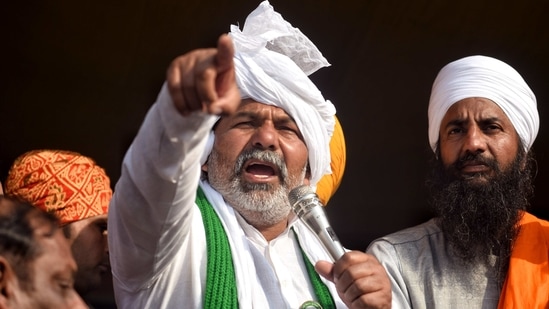 Farmer leader Rakesh Tikait addresses farmers during their ongoing protest against new farm laws at Delhi-Ghazipur border, in Delhi on Sunday. (ANI Photo )