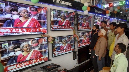 People watch finance minister Nirmala Sitharaman presenting Union Budget 2021-21 on television sets, at an electronics store in Prayagraj on Monday. (PTI) People watch finance minister Nirmala Sitharaman presenting Union Budget 2021-21 on television sets, at an electronics store in Prayagraj on Monday. (PTI)