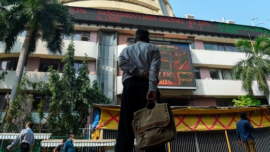 A pedestrian watches a digital screen relaying the budget speech by Finance Minister Nirmala Sitharaman on the facade of the Bombay Stock Exchange (BSE) in Mumbai on February 1. In Budget 2021-22, the income tax slabs have stayed the same as the previous year. Only those above 75 years, who depend on pension income, were exempt from ITR filing.(Punit Paranjpe / AFP)
