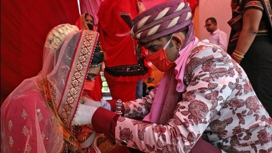 A couple performs marriage rituals wearing protective masks, in New Delhi in May 2020. (File photo) A couple performs marriage rituals wearing protective masks, in New Delhi in May 2020. (File photo)