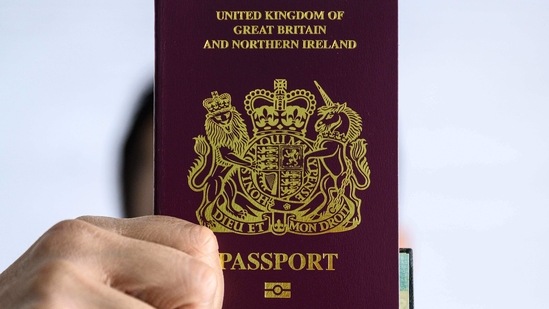 (FILES) This file photo taken on January 29, 2021 shows a person holding up a British National (Overseas), or "BNO", passport in Hong Kong. - A new visa scheme offering millions of Hong Kongers a pathway to British citizenship will go live later on January 31, 2021 as the city's former colonial master opens its doors to those wanting to escape China's crackdown on dissent. (Photo by Anthony WALLACE / AFP)(AFP)