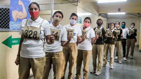 Women police personnel wait in a queue to get the first shot of Covid-19 vaccine at a vaccination centre at Civil Hospital, in Ahmedabad on Sunday.(PTI Photo)
