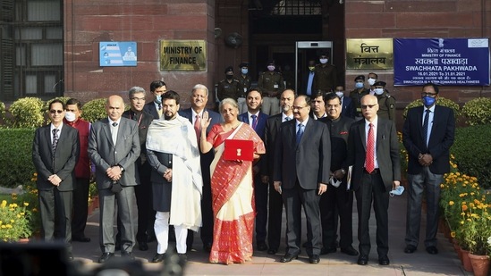 Finance minister Nirmala Sitharaman holds a bahi khata containing the Union Budget 2021-22 as she poses for a group photograph with MoS Finance Anurag Thakur and other members of finance ministry, at North Block in New Delhi on Monday.(PTI Photo)