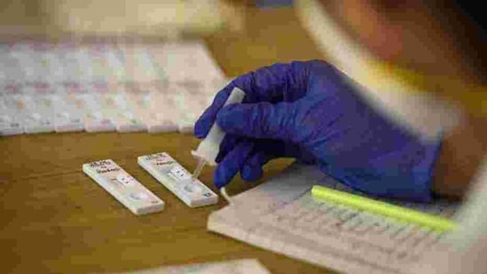 A health worker testing for Covid-19 using rapid antigen methodology in Shivaji Nagar, Gurugram, on Sunday.(PARVEEN KUMAR/HT)