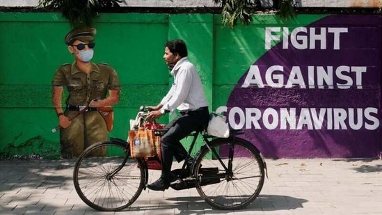 A man cycles past a graffiti covered wall amidst the spread of the coronavirus disease (COVID-19) on a street in Navi Mumbai on January 30. India has inoculated as many at 3.7 million beneficiaries, since the launch of a nationwide Covid-19 vaccination programme on January 16, the health ministry states.(Francis Mascarenhas / REUTERS)