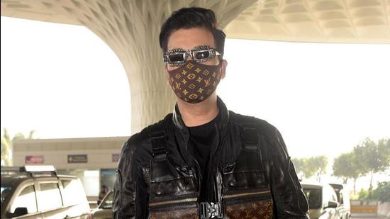 Karan Johar at the airport matches his mask logo print with the monogram print on his jacket (Photo: Yogen Shah)