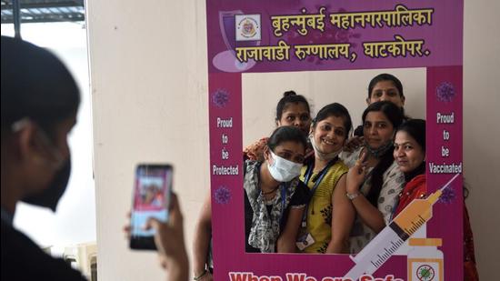 People taking a group photo at a booth after being administered a Covid-19 vaccine shot at Rajawadi Hospital. (Satish Bate/HT Photo) People taking a group photo at a booth after being administered a Covid-19 vaccine shot at Rajawadi Hospital. (Satish Bate/HT Photo)